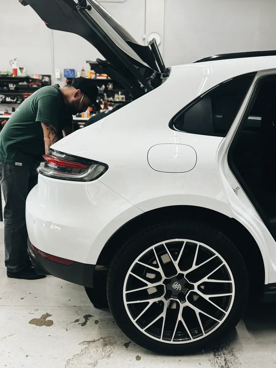 FRQNCY technician installing audio equipment in a Porsche Macan trunk
