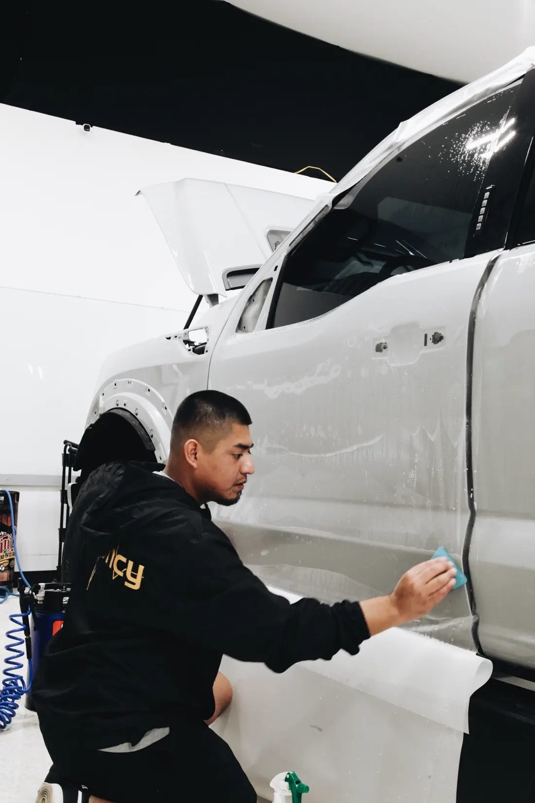 FRQNCY technician applying protective film in the Woods Cross shop